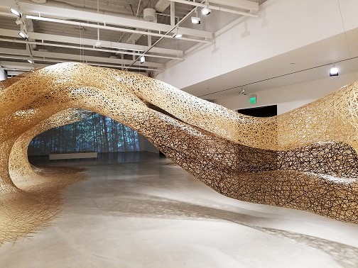 installation art of Tanabe Chikuunsai IV resembling wormholes or tunnels comprised of numerous interlocking bamboo strands